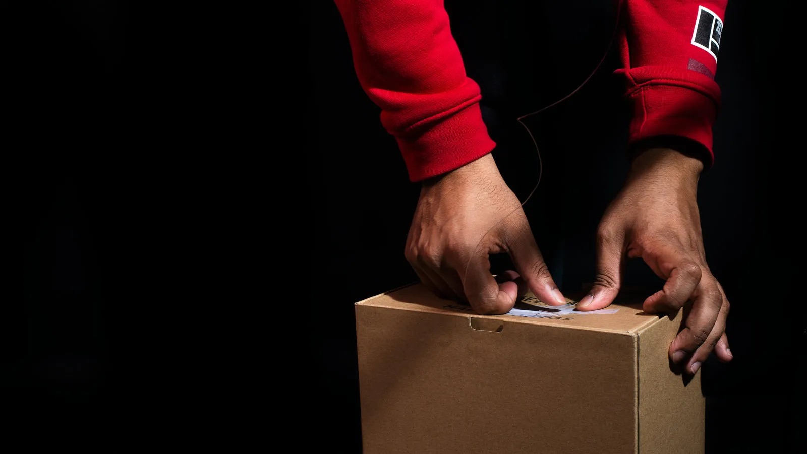 A packaging box lit from one side, in deep shadow